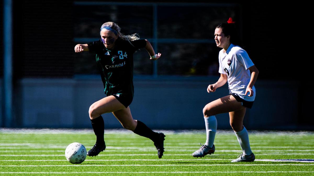 Hannah Jordan (34) runs down the field with the ball during the 6A Regional Final between the Carroll Lady Dragons and the Marcus Marauders at McKinney ISD Stadium on April 9th, 2022.