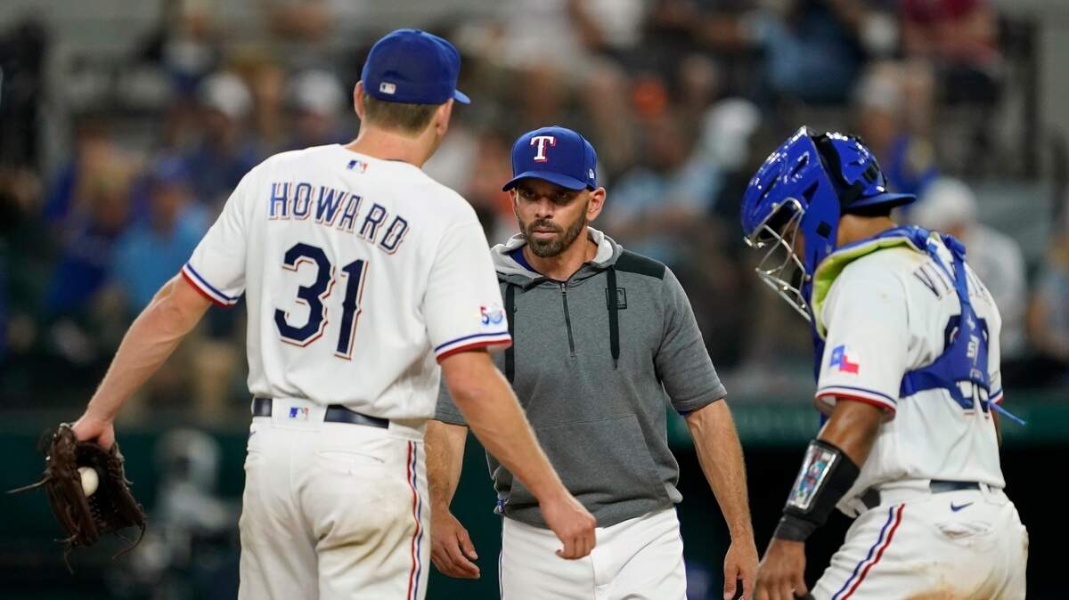 Texas Rangers starting pitcher Spencer Howard (31) talks Rangers manager Chris Woodward, center, talks with pitcher Spencer Howard (31) and catcher Meibrys Viloria during Tuesday’s game.