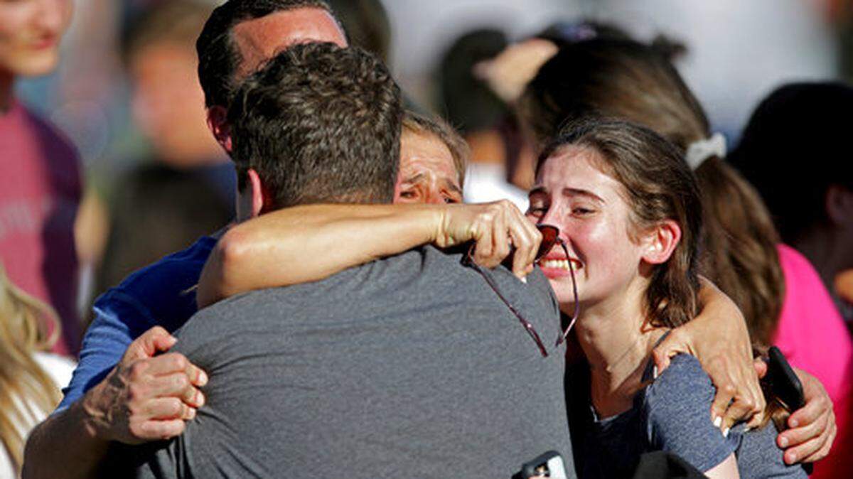 In this Wednesday, Feb. 14, 2018, file photo, a family reunites following a shooting at Marjory Stoneman Douglas High School in Parkland, Fla. A commission tasked with investigating government actions surrounding the Florida high school massacre and the state’s other mass shootings is set to hold its first meeting, Tuesday, April 24. File photo.