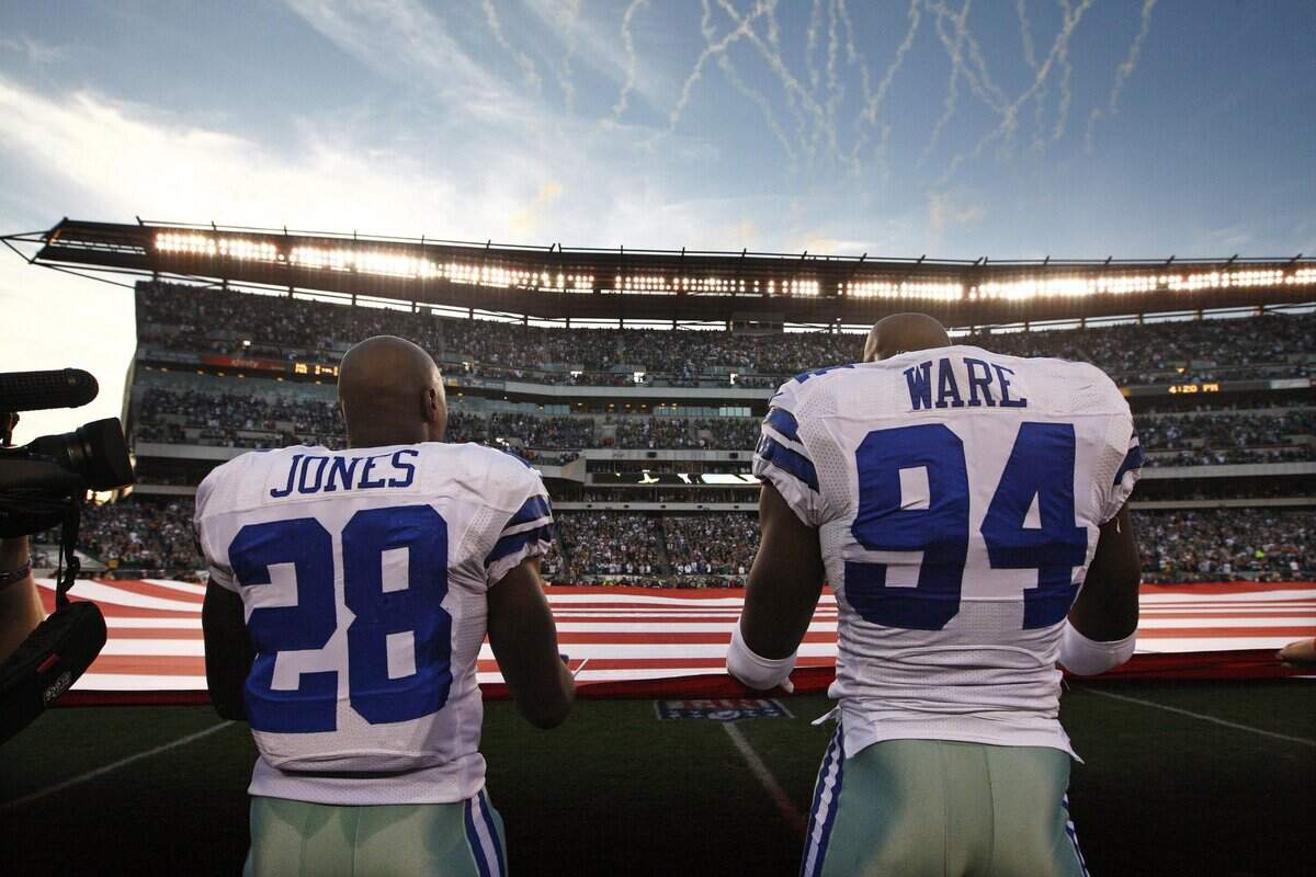 Nov. 11, 2012: Felix Jones and DeMarcus Ware join teammates holding a large U.S. flag for a Veterans Day pre-game ceremony before the Dallas Cowboys play the Philadelphia Eagles at Lincoln Financial Field.