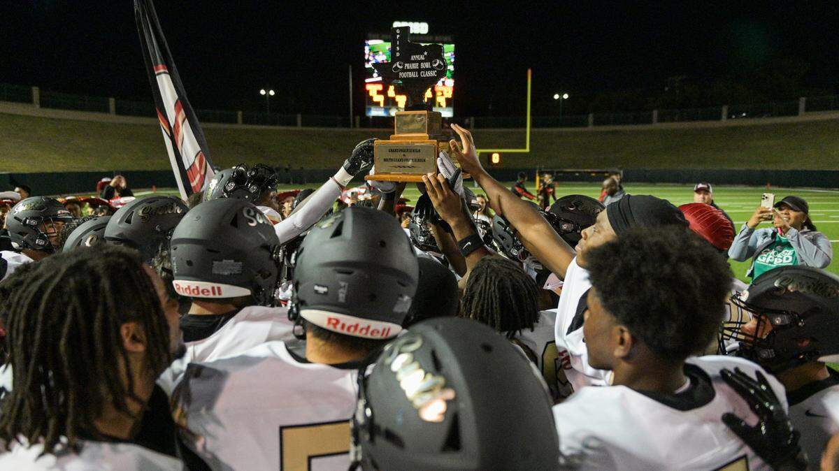 South Grand Prairie Warriors lift a trophy after a UIL football game against South Grand Prairie High School at Gopher-Warrior Bowl in Grand Prairie, Texas on Friday, Oct. 18, 2024.