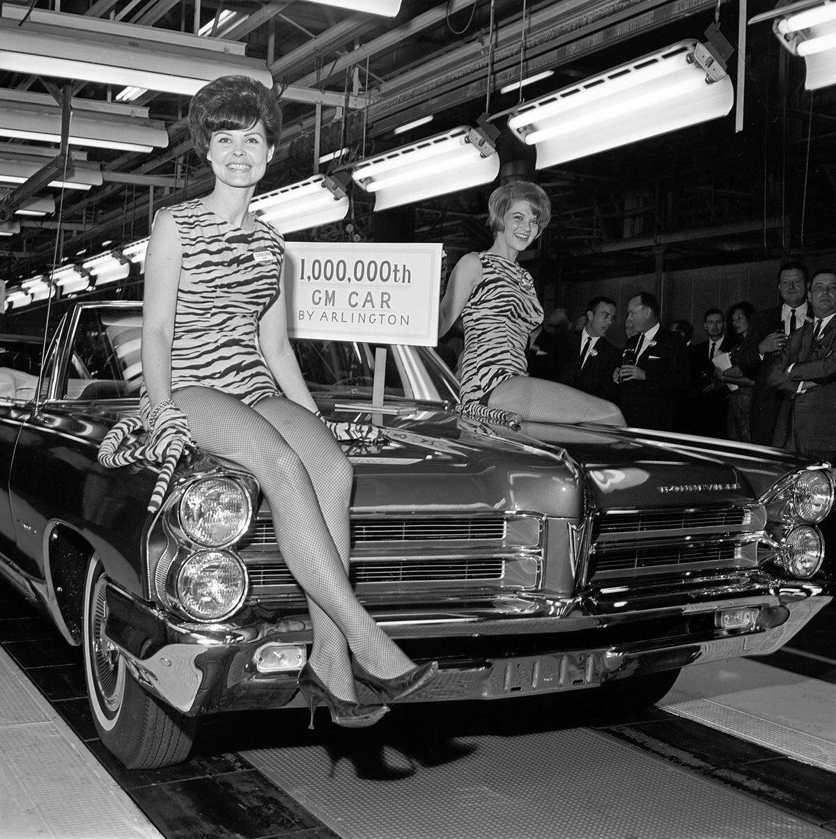 July 19, 1965: A shining 1965 Pontiac convertible moves down the General Motors assembly line to become the 1 millionth automobile produced at the Arlington plant, which opened in 1954. Two models, Betty Cremer and Shirley Deis, wearing tiger outfits sit on the hood.