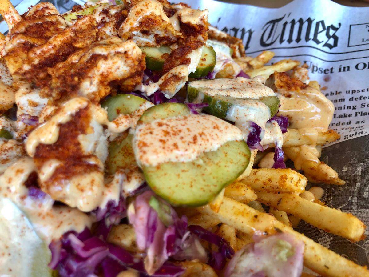 “Dirtybird” fries are covered with hot chicken strips, special sauce, Cajun and garlic seasonings at FireHouse Gastro Park in Grand Prairie.