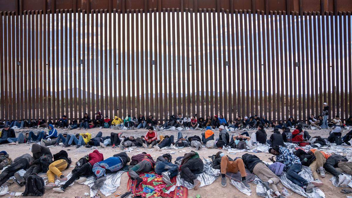 Migrants and asylum seekers wait Dec. 4 to be picked up and processed by U.S. Border Patrol agents in Organ Pipe Cactus National Monument along the U.S.-Mexico border in Arizona.