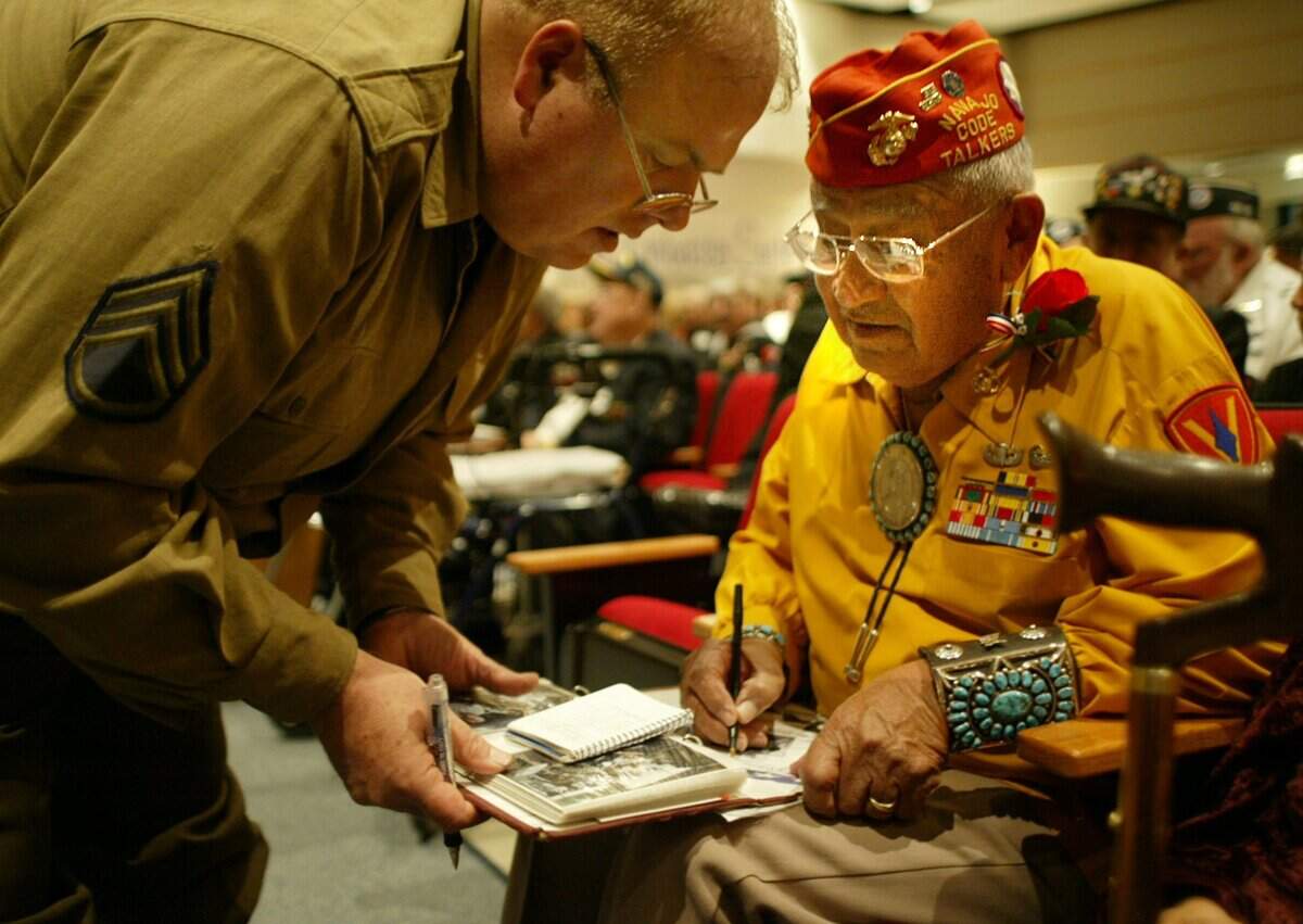Nov. 10, 2005: Matt Larsen of Plano, who served in the Army from 1968 to 1969 in Germany, receives a written note and signature in his military scrap book from Thomas H. Begay of Arizona, a Navajo code talker during World War II, at the Veterans Day ceremony at Grapevine High School.