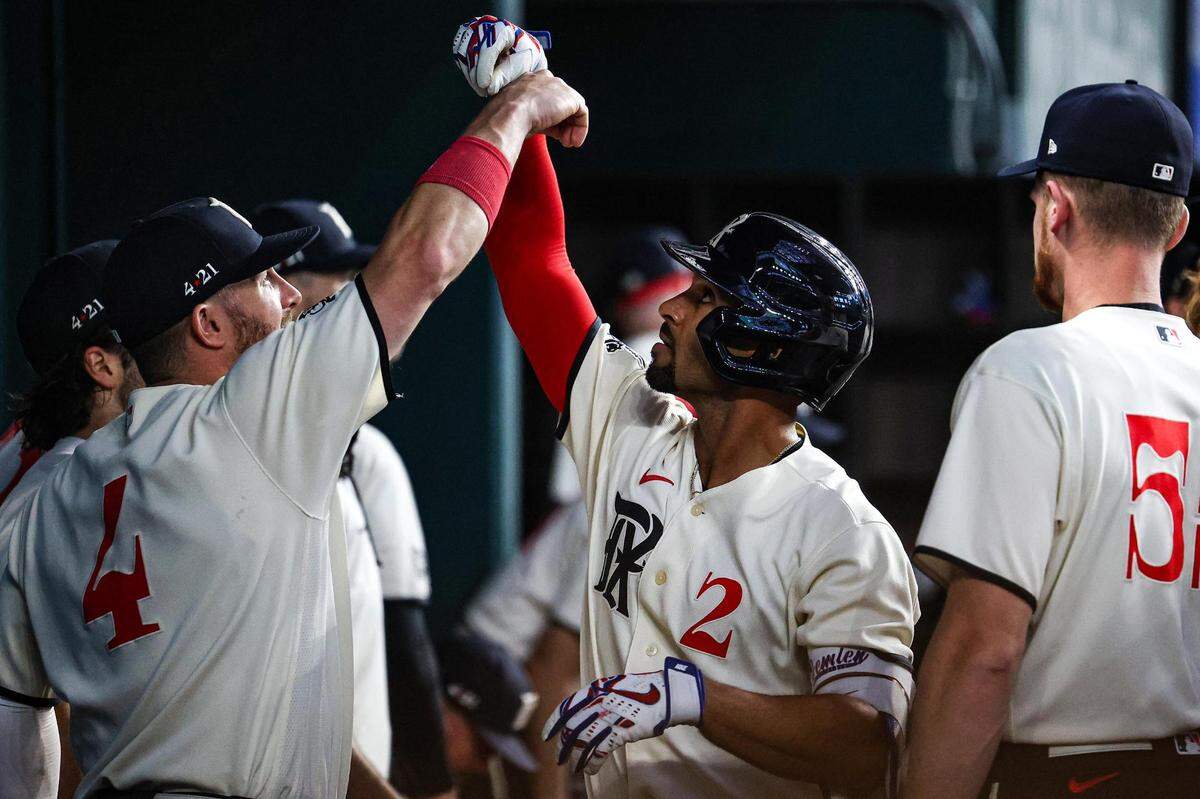 Texas Rangers infielder Marcus Semien (2) celebrates with outfielder Robbie Grossman (4) after hitting a lead off home run in the first inning of a regular season match up against the Los Angeles Dodgers at Globe Life Field in Arlington, Texas on Saturday, July 22, 2023. The Rangers gave up 18 hits and lost 16-3.