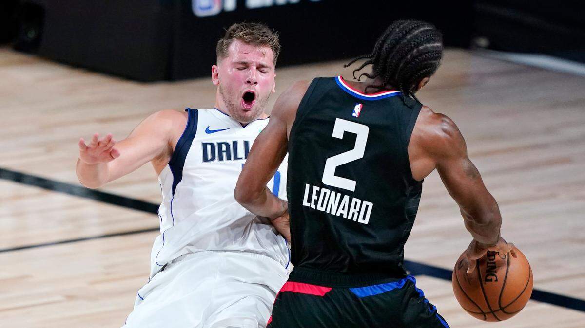 Dallas Mavericks’ Luka Doncic collides with Los Angeles Clippers’ Kawhi Leonard (2) during the first half of an NBA basketball game Wednesday, Aug. 19, 2020, in Lake Buena Vista, Fla. (AP Photo/Ashley Landis, Pool)