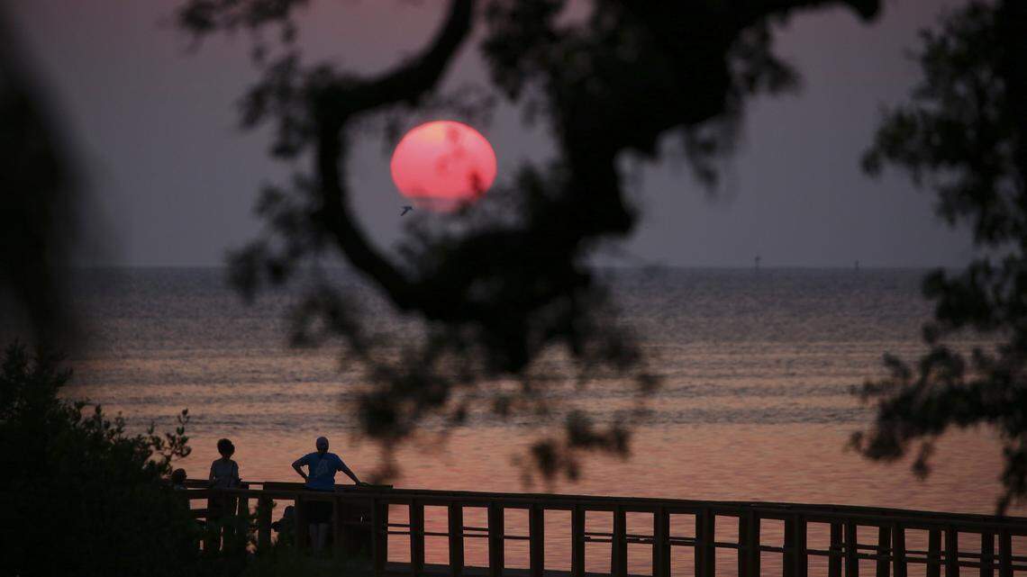 The sun sets over the Crystal Beach pier in Palm Harbor on June 30. Sunsets soon could be even more stunning than usual in Tampa Bay. Meteorologists say Sahara Desert dust clouds are blowing across the Atlantic Ocean.
