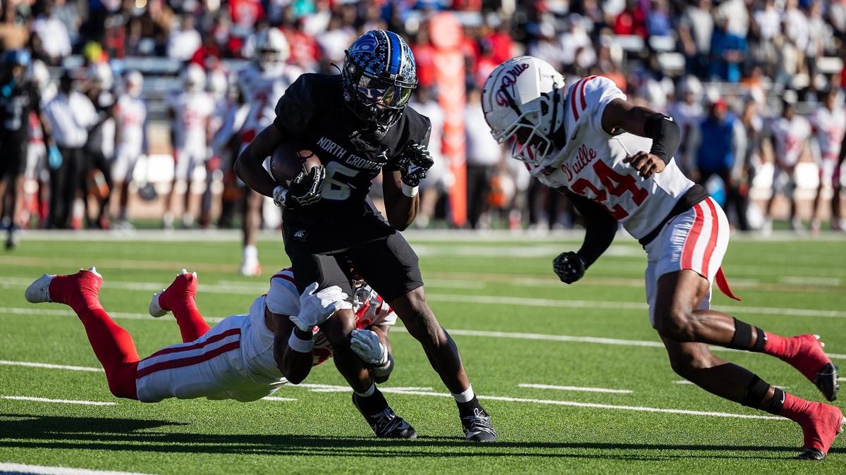 Duncanville defensive back Tyren Polley (21) dives to tackle North Crowley wide receiver Quentin Gibson (6) while Duncanville defensive back Travyon Cherry (24) goes in for a hit prior to scoring a touchdown in the first half of the Class 6A Division I state semifinal game at Eagle Stadium in Allen on Saturday, Dec. 14, 2024.