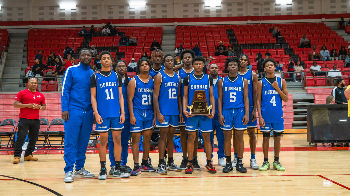 The Fort Worth Dunbar boys basketball team poses with the Class 4A Region II bi-district trophy after defeating Venus 90-48 on Tuesday, February 20, 2024 at Burleson High School in Burleson, Texas.