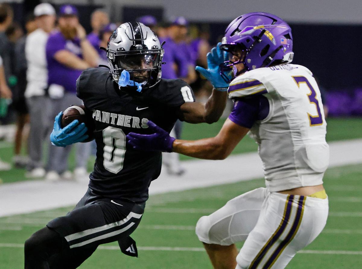 Panther Creek wide receiver Jalen Lott (0) stiff arms Alvarado defensive back Schyler Dethorne (3) as he is driven out of bounds during a UIL 4A D1 Area round football playoff game at The Ford Center in Frisco Texas, Thursday, Nov. 21, 2024.