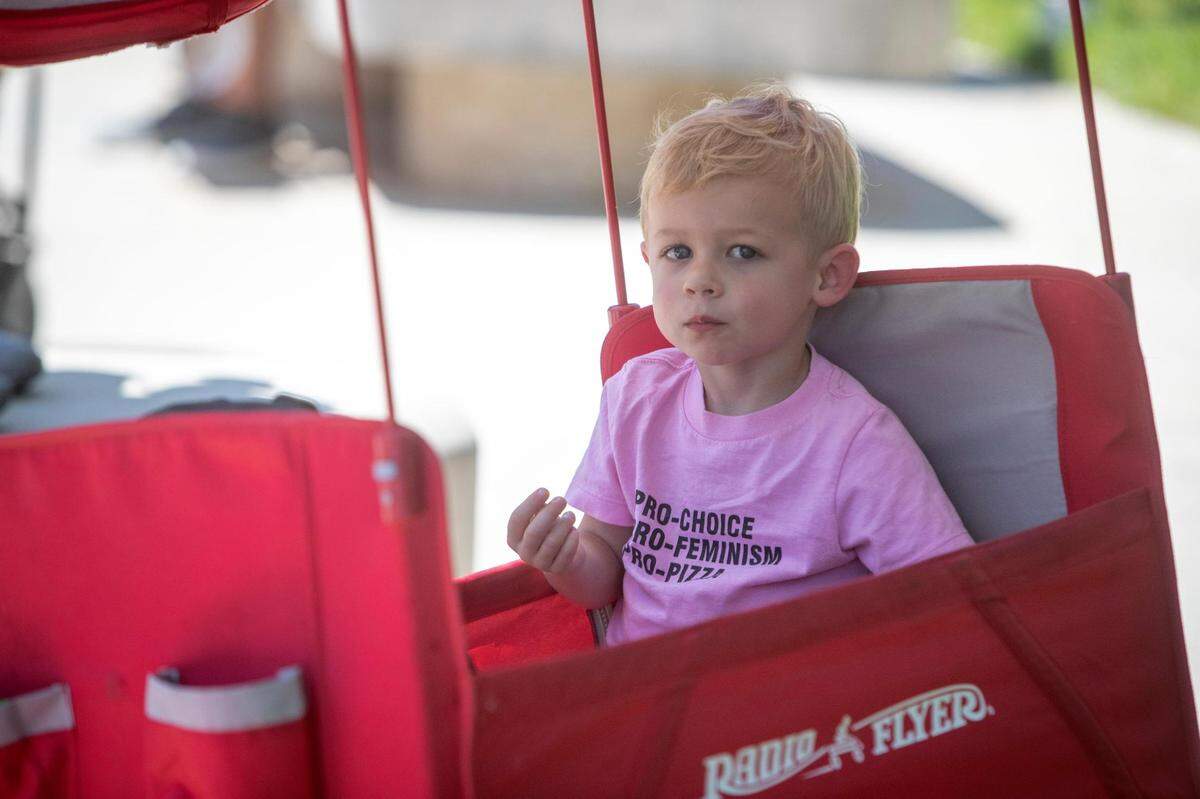 Oliver Triche, 2, rests in the shade during the Bans Off Our Bodies protest with his mom, Michelle, outside of the Tarrant County Courthouse on Saturday, June 25, 2022. Hundreds of abortion-rights advocates gathered at the steps of the courthouse before marching downtown with a rallying cry of “My body, my choice.”