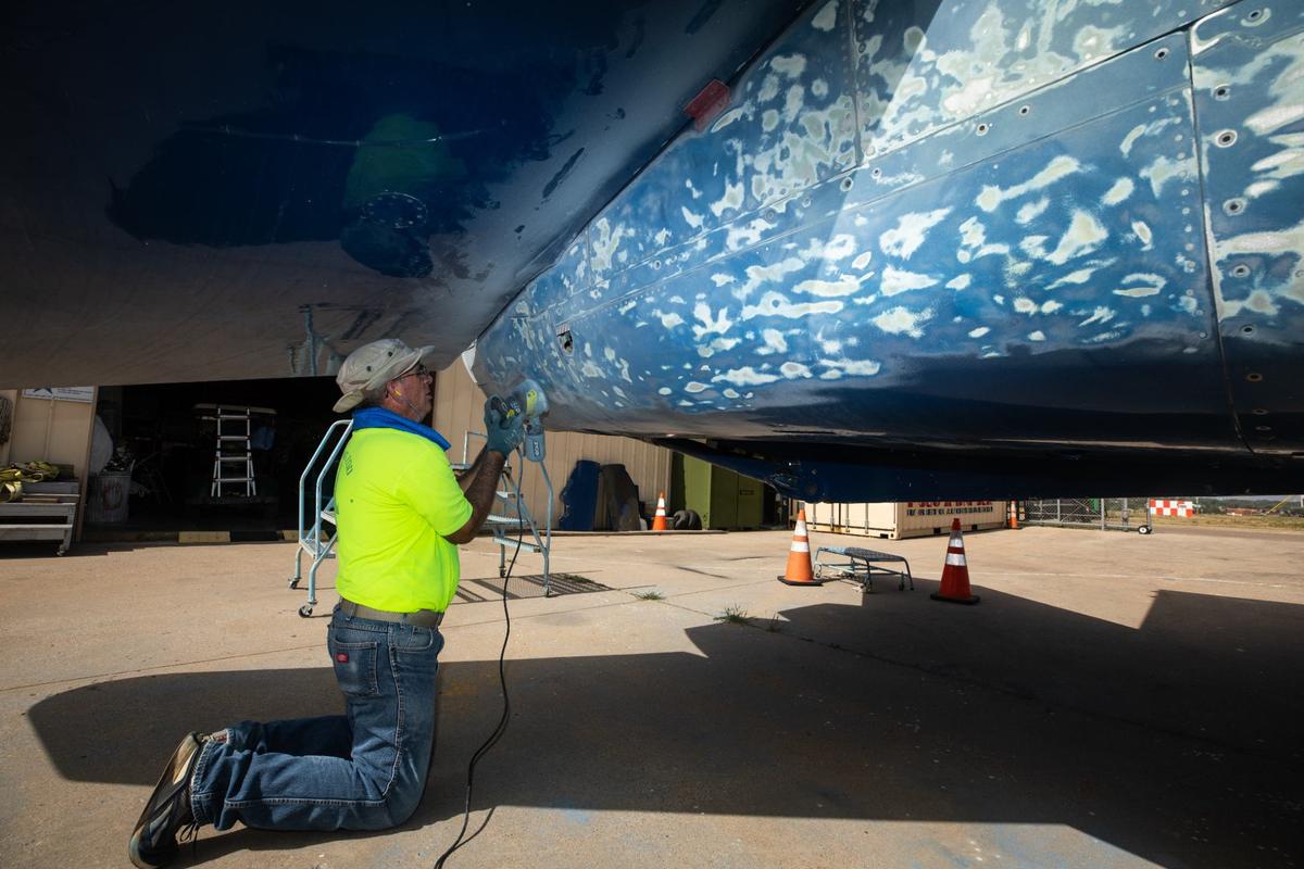 Air force veteran Keven Nelson sands the paint off a retired Blue Angels F-18 Hornet on Thursday, August 1, 2024 at the Fort Worth Aviation Museum. After receiving the F-18 from the National Naval Aviation Museum in Pensacola, Florida due to sun damage the restoration team plans on restoring the paint to its original glossy finish.