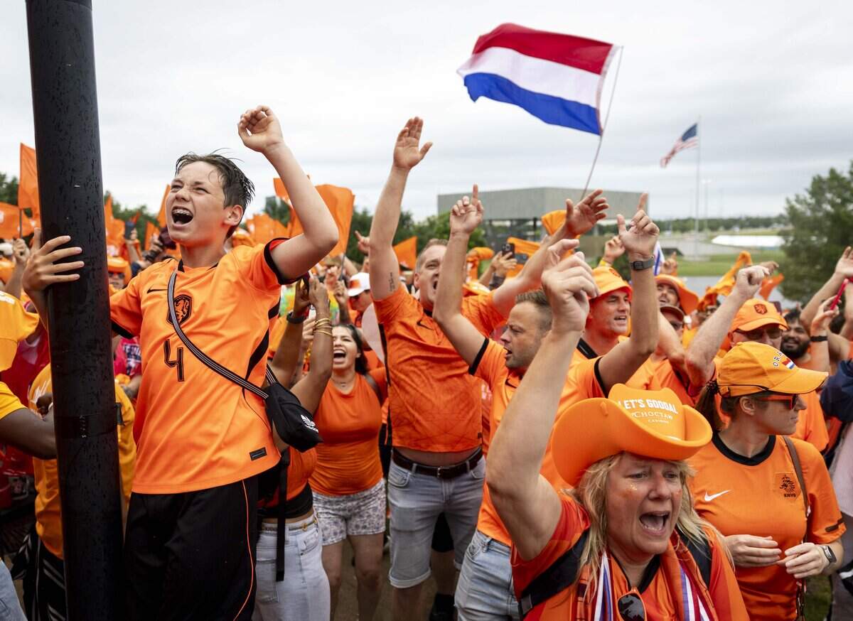 Netherlands soccer chant and sing along before they march to Dallas Stadium ahead of the FIFA World Cup match against Japan on Sunday, June 14, 2026 in Arlington, Texas. The famous double-decker Dutch Orange Bus, or De beroemde Oranjebus, is part of a Netherlands fan tradition bringing a sea of orange to the streets before major soccer matches.