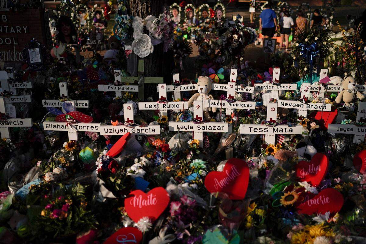 Flowers are piled around crosses with the names of the victims killed in last week’s school shooting as people visit a memorial at Robb Elementary School to pay their respects, Tuesday, May 31, 2022, in Uvalde, Texas. (AP Photo/Jae C. Hong)