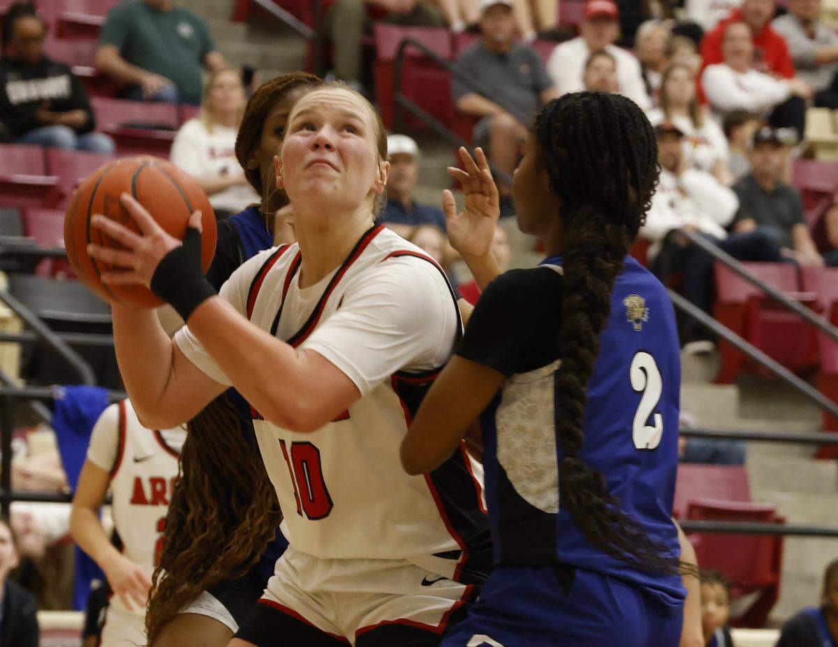 Argyle forward Emma King (10) gets a shot off defender by Mansfield Summit guard Aryn Williamson (2) during the first half of a UIL Class 5A DII girls playoff basketball game at Saginaw High School in Saginaw, Texas, Thursday Feb. 19, 2026.