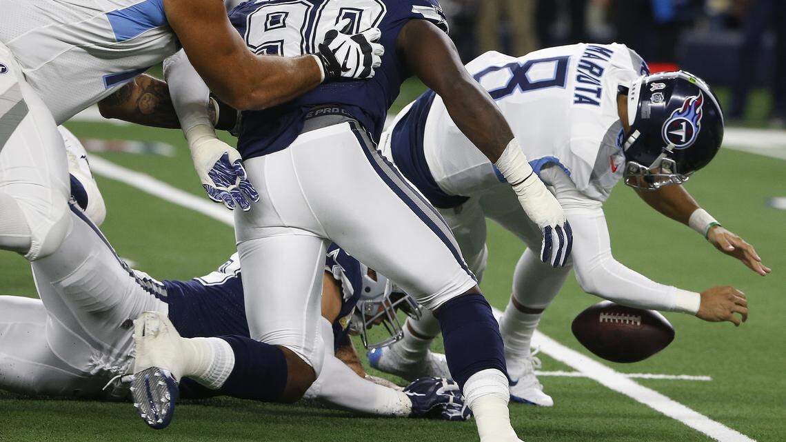 Tennessee Titans quarterback Marcus Mariota, right, fumbled the ball in the first half Monday night. It was recovered by Cowboys’ linebacker Sean Lee, who left the game in the second half with a hamstring injury.