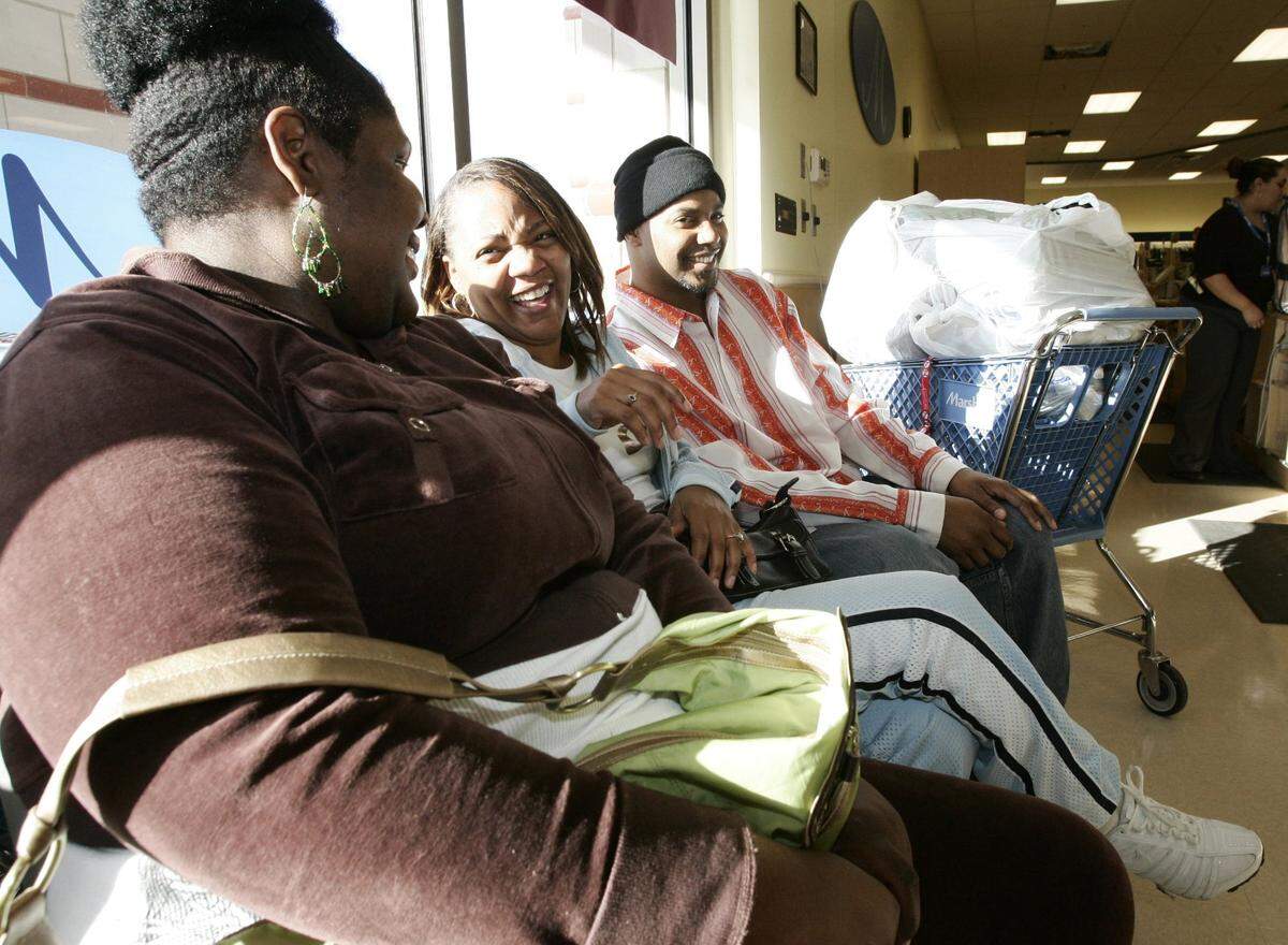 Nov. 24, 2006: Michelle Spellmon, Tanja Webster and her husband Patrick Webster take a break after making their Black Friday purchases at Marshall’s in Montgomery Plaza in Fort Worth. The group started shopping at Best Buy at 5 a.m and still had another store or two to go at 9 a.m.