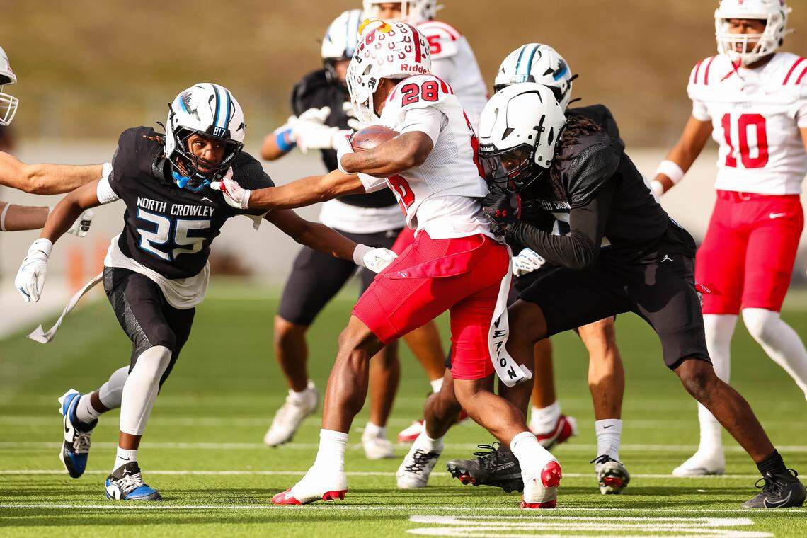 Coppell returner Dylan McAfee (28) is tackled by two North Crowley defenders in a Class 6A Division I regional playoff Saturday, Nov. 29, 2025, at Midlothian ISD Stadium in Midlothian.