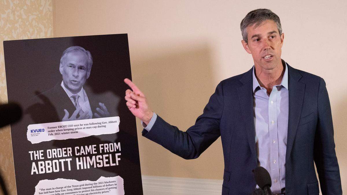 Beto O’Rourke stands next to an image of Texas Gov. Greg Abbott as he speaks during a press conference announcing that he’s being sued for defamation by Dallas billionaire Kelcy Warren, on Monday, March 7, 2022 at a Hilton Garden hotel in Dallas.