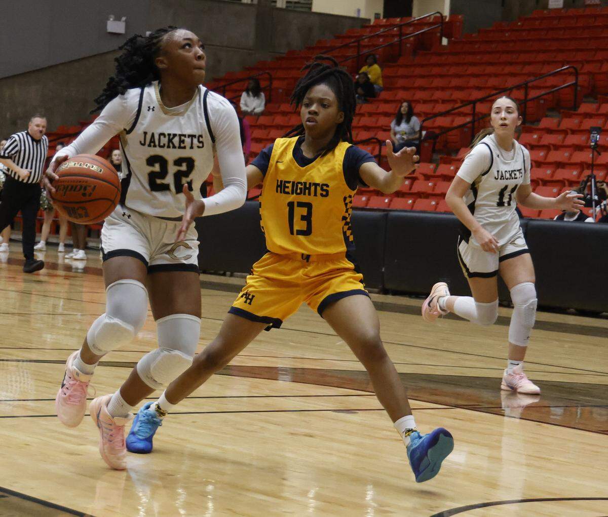 Cleburne guard Arajai Burks (22) drives into the lane defended by Arlington Heights guard Taniyah Clemons (13) during the first half of the UIL 5A D1 girls bi-district championship basketball game at Wilkerson Greines Activity Center in Fort Worth, Texas, Monday Feb. 16, 2026.