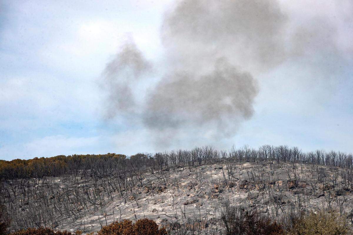 Smoke rises from a wildfire on the coast of Possum Kingdom Lake in Graford, Texas, on Wednesday, July 20, 2022.