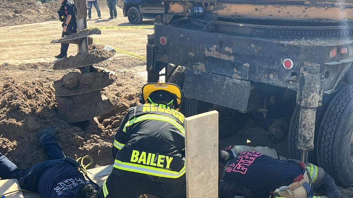 Firefighters work to recover a construction worker who died in a collapsed hole, officials said.