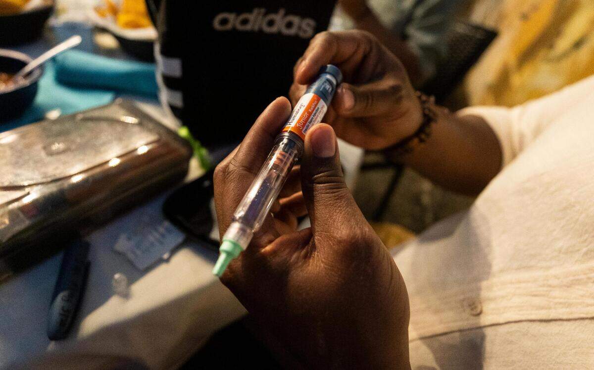 Marlon Green gets ready to give his son Neyo an insulin shot before they eat dinner at Joe T. Garcia’s in Fort Worth. The family has become an expert at handling his care in the months since he was diagnosed with Type I diabetes.