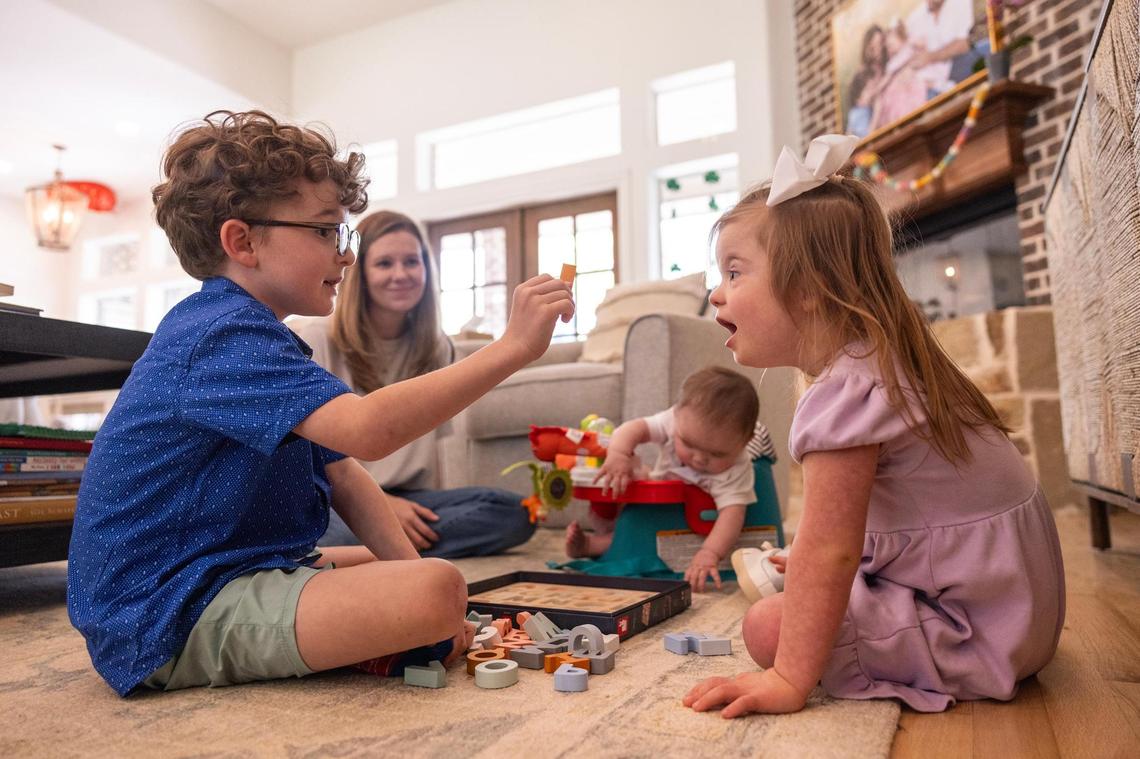 Wells Morey, 7, plays with his sister, Annie, 4, in the living room of their home in Parker County on Friday, March 28.