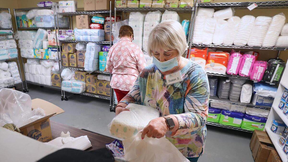 Susan Stamy puts together a bag of diapers and wipes for a mother while volunteering at the diaper bank at Community Crossroads in July 2021. Community Crossroads is hosting a resource fair with free medical and vision screenings and other services Tuesday.