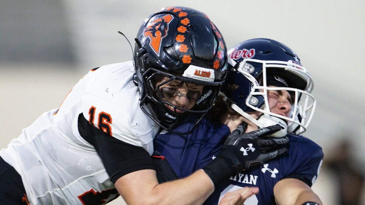 Denton Ryan quarterback Quin Henigan (9) is tackled by Aledo linebacker Cole Cox (16) for a safety in the first half of a high school football game between the Aledo Bearcats and the Denton Ryan Raiders at C.H. Collins Athletic Complex in Denton on Friday, Oct. 3, 2025.