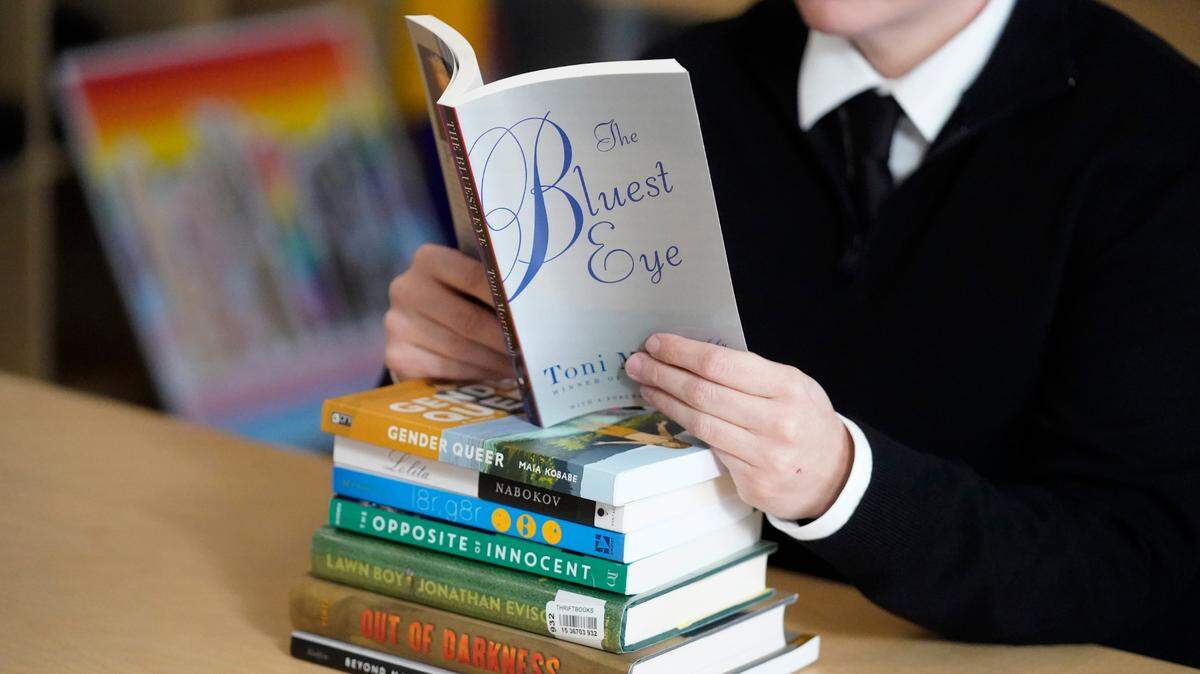 Amanda Darrow, director of youth, family and education programs at the Utah Pride Center, poses with books that have been the subject of complaints from parents, in a 2021 archive photo. Some of the same books have been challenged in Fort Worth.