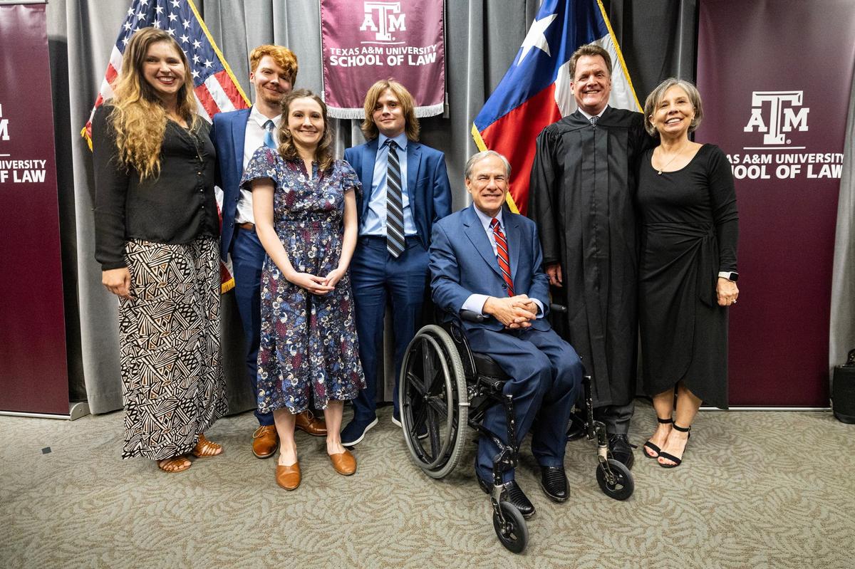 Texas Governor Greg Abbott takes a photo with newly appointed Eighth Division Business Court Justice Jerry Bullard and his family following his official swearing in ceremony at the Texas A&M Law School in downtown Fort Worth on Thursday, Sept. 19, 2024.