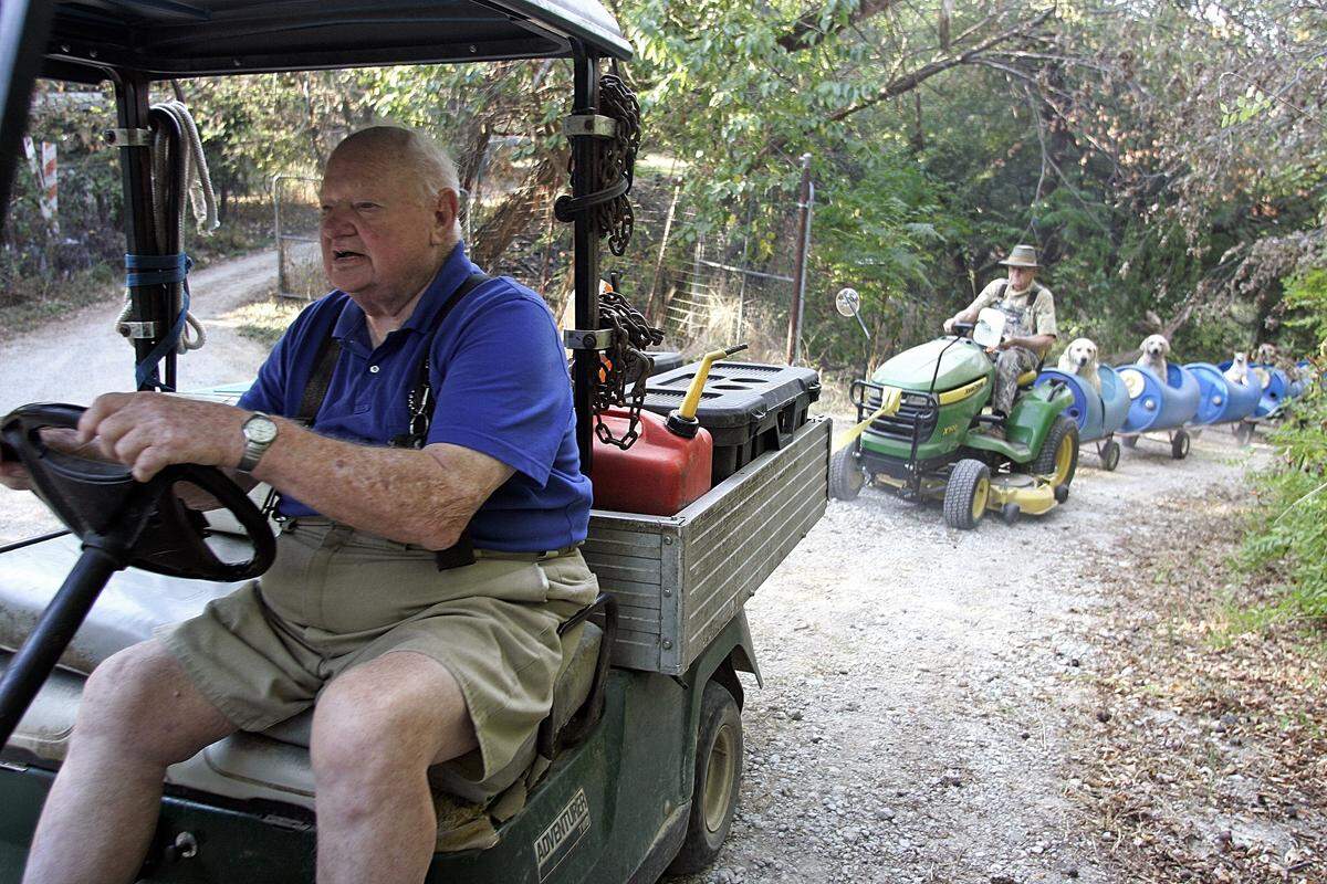 Walter Bostick adds another engine to help pull brother Eugene Bostick and his train of eight dogs up a steep hill on their ride around the property Thursday morning Sept. 24, 2015. Bostick drives the dogs around the 12 acre property about 2-3 times a week. (Special to the Star-Telegram Bob Booth)