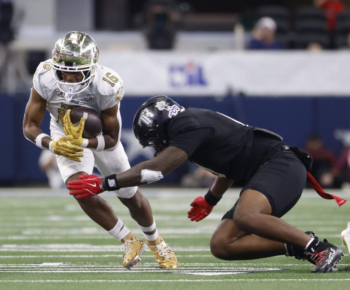 Richmond Thomas Randle defensive back Jalyn Burton (5) reaches in for Dallas South Oak Cliff wide receiver Delvin Cook (16) during the first half of the UIL Class 5A Division II championship game on Saturday Dec. 20, 2025 at AT&T Stadium in Arlington, Texas.