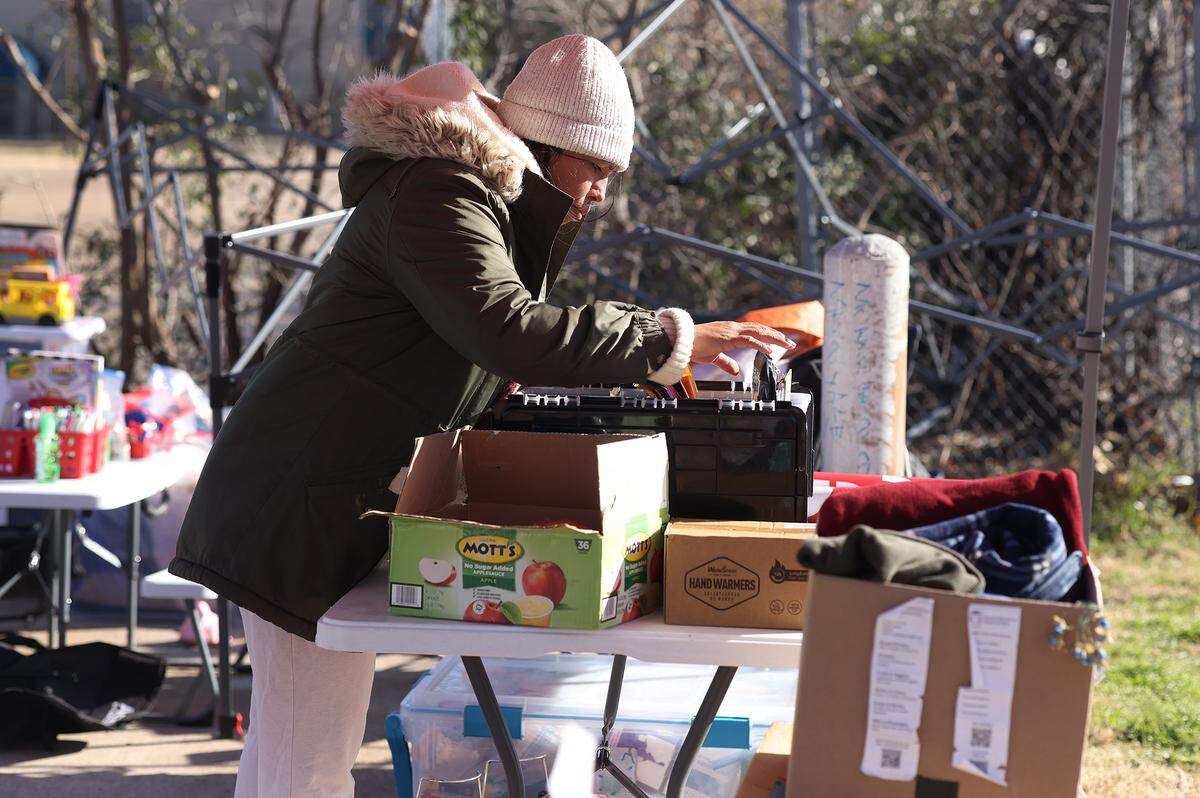Community organizer Sandra Avalos sifts through paperwork while volunteering outside of the U.S. Immigration and Customs Enforcement (ICE) field office in Dallas on Friday, Jan. 16, 2026.