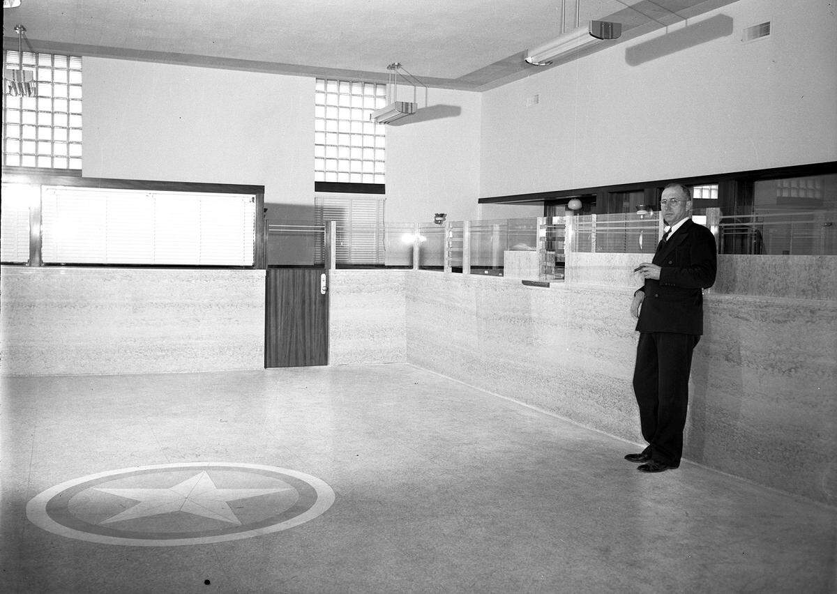 March 24, 1942: D.E. Box, president of the new First National Bank at Grapevine, Texas, shown standing inside the bank building.