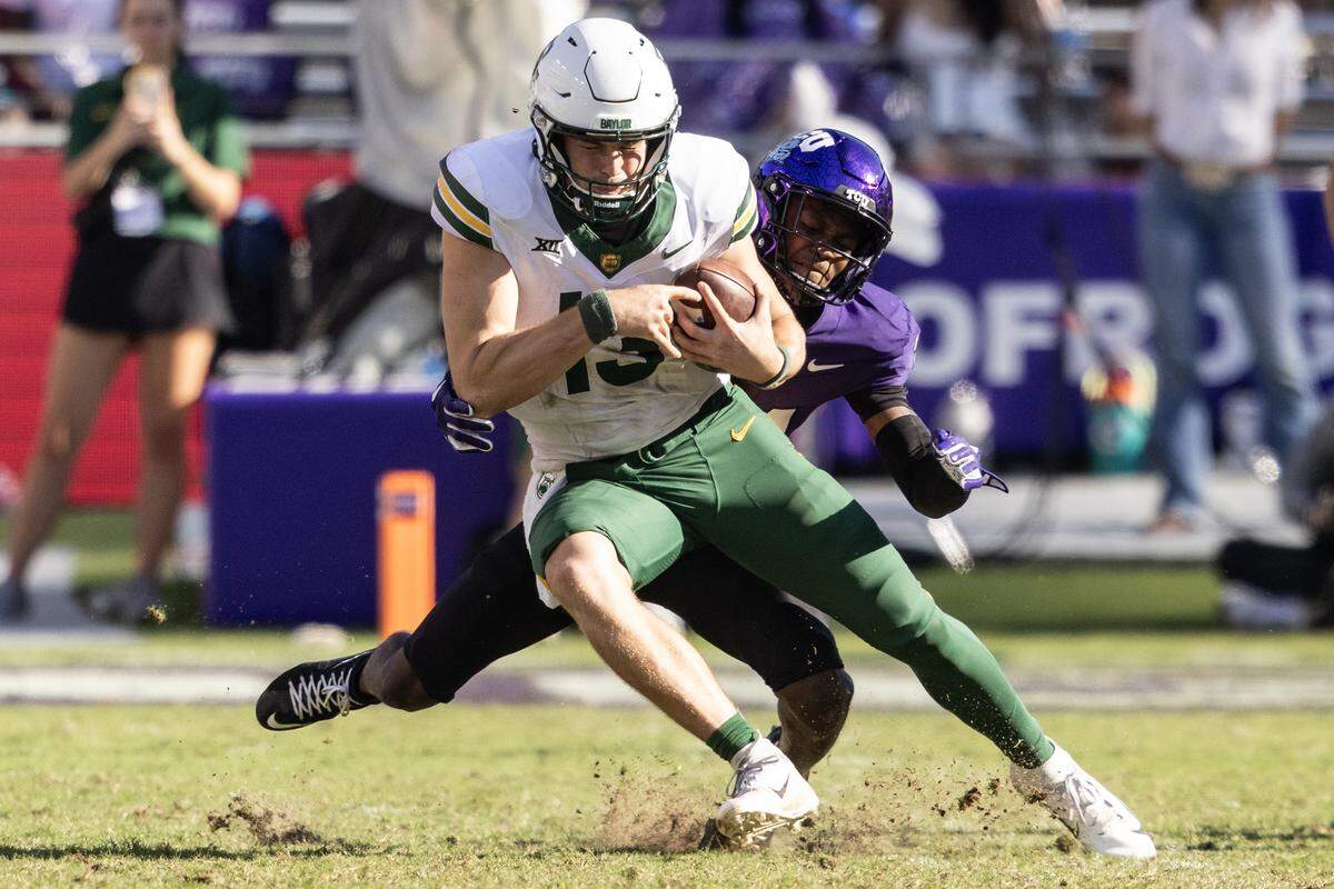 Baylor quarterback Sawyer Robertson (13) is sacked by TCU safety Bud Clark (21) in the second half of a Big XII football game between the TCU Horned Frogs and the Baylor Bears at Amon G Carter Stadium in Fort Worth on Saturday, Oct. 18, 2025.