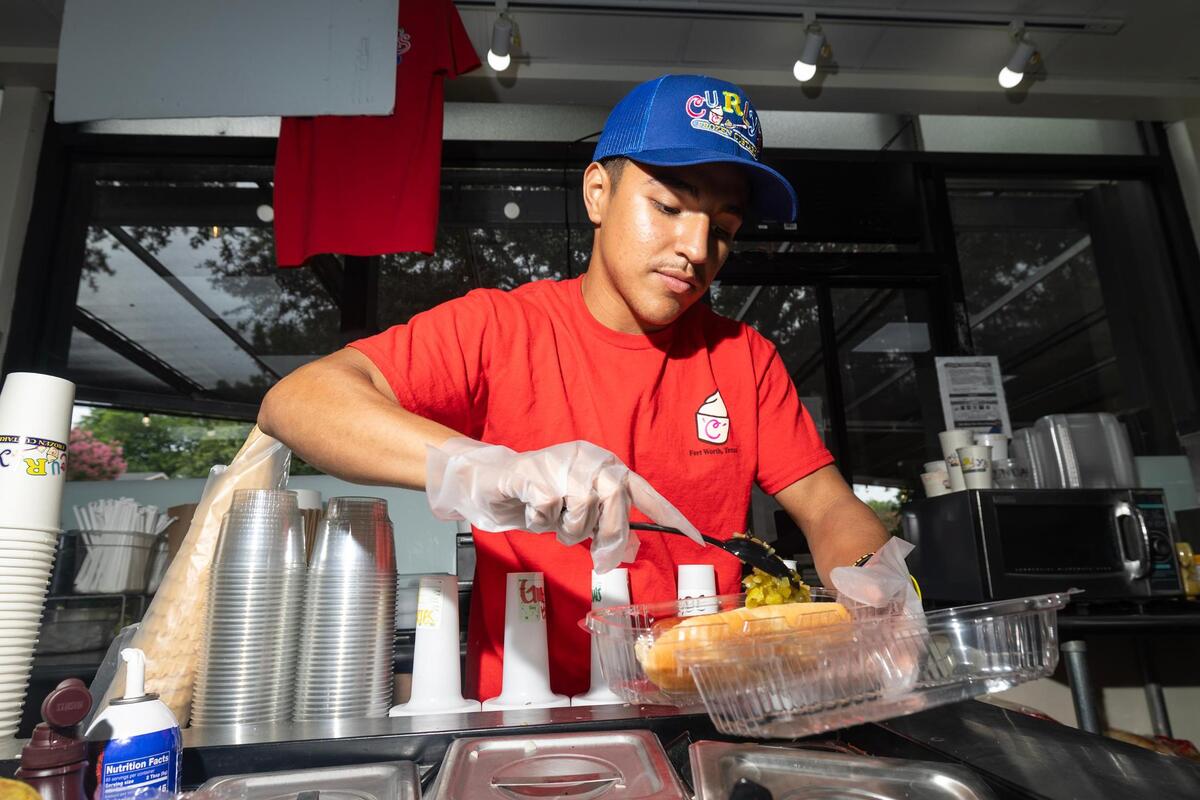 Team member Rudy Alderete makes the ‘Chuckwagon Dog’ and the ‘Chicago Dog’ during service at Curly’s Frozen Custards in Fort Worth on Wednesday, July 2, 2025. Curly’s is the winner of the recent Star-Telegram poll to find the best hot dog in Fort Worth.