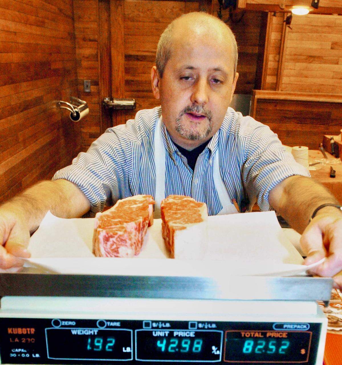 Paul Murray, a butcher at Lobel’s of New York, weighs a pair of New York strip steaks, also known as Kansas City strips, in a shop on Madison Avenue December 26, 2003. “All of our beef comes from the Midwest,” said Mark Lobel, the shop’s co-owner and fifth-generation butcher. Lobel’s opened in 1840 and has been on Madison Avenue for 50 years.