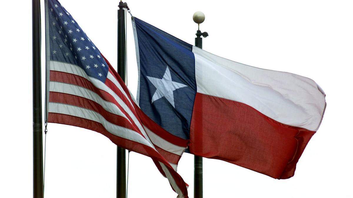 A United States flag, left, and a Texas flag, fly near the LBJ Freeway in Dallas, Monday, Feb. 26, 2001. (AP Photo/Donna McWilliam)