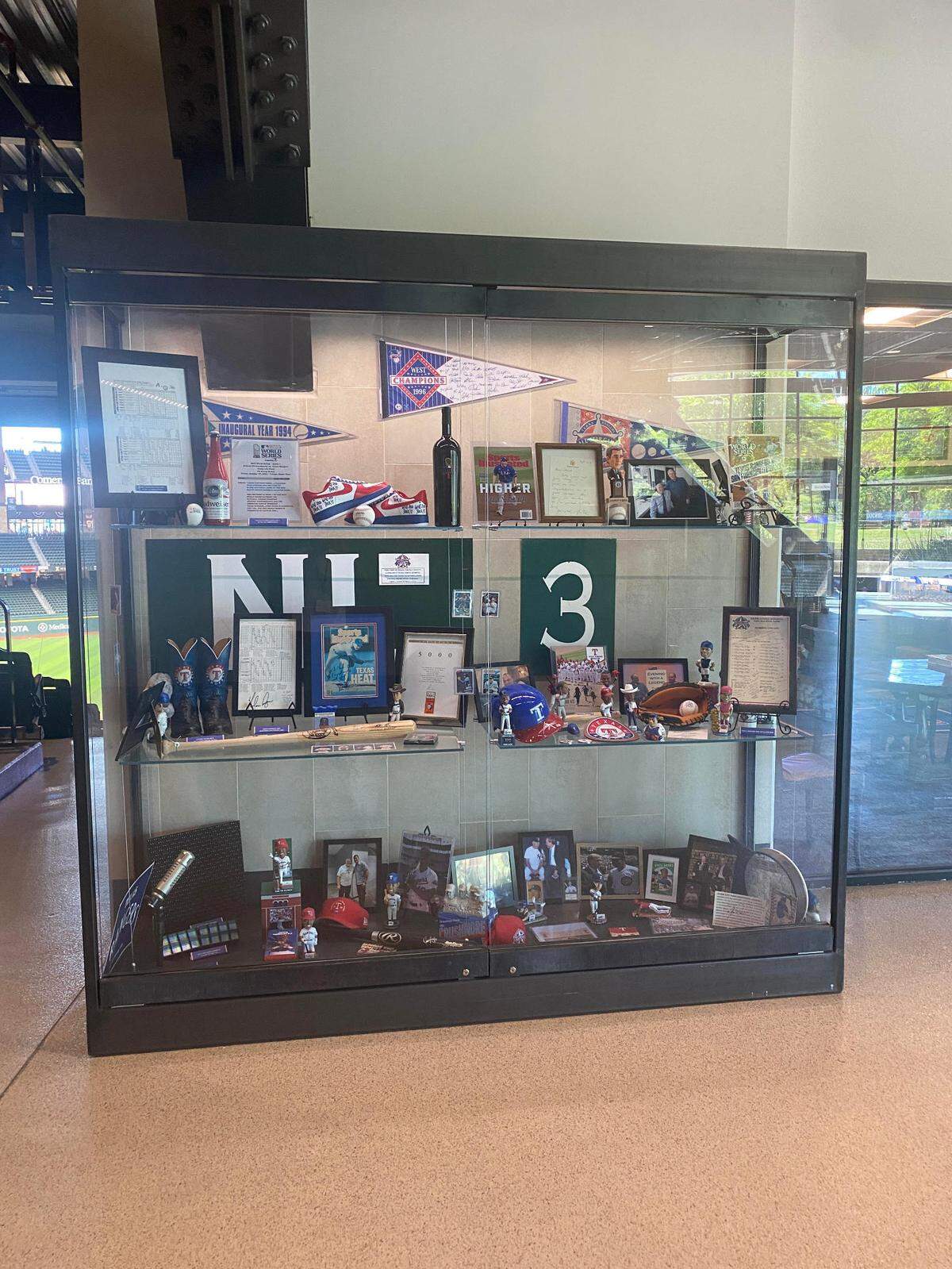 A display case showcasing mementos from Texas Rangers history including the public announcer script from game 1 of the World Series.