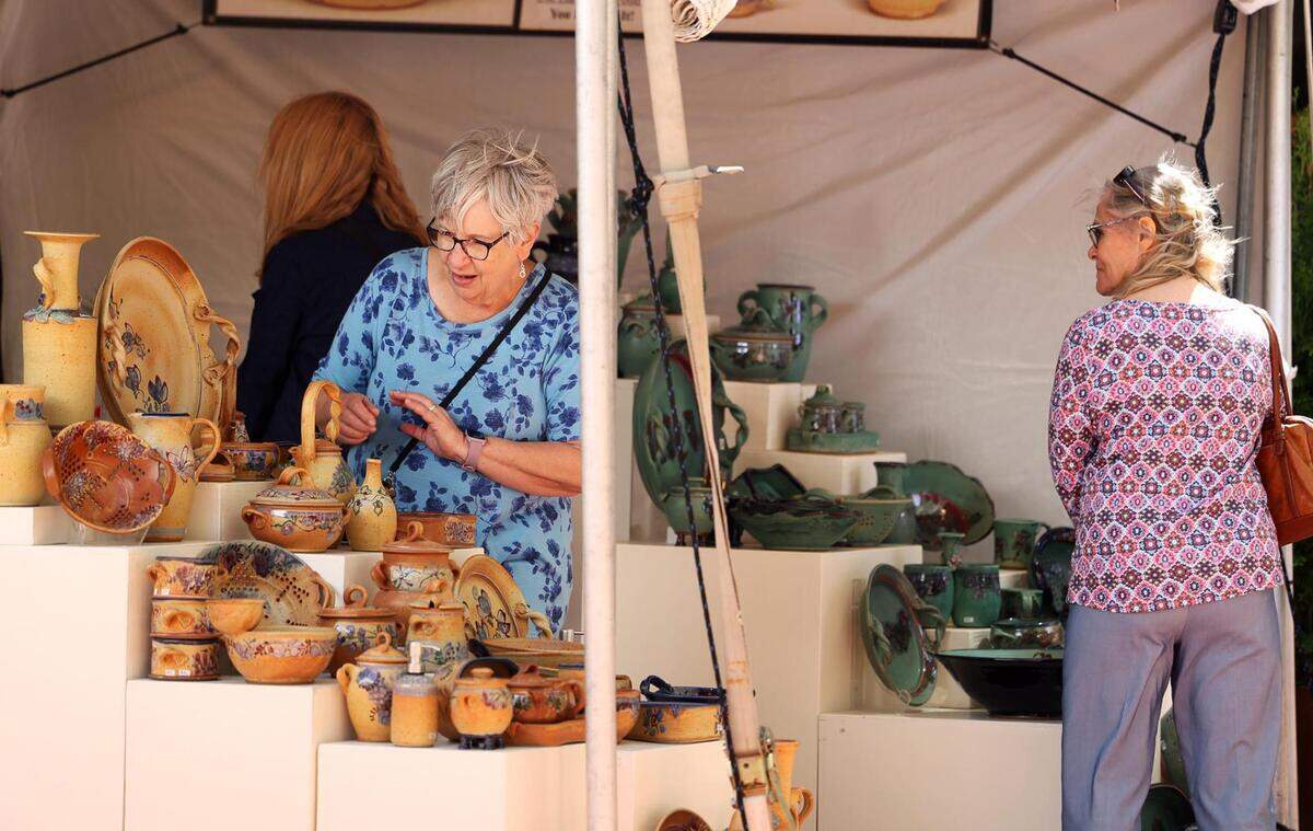 Visitors to the Main Street Arts Festival look at the pottery of one of the over 200 juried artists on Friday, April 21, 2023.