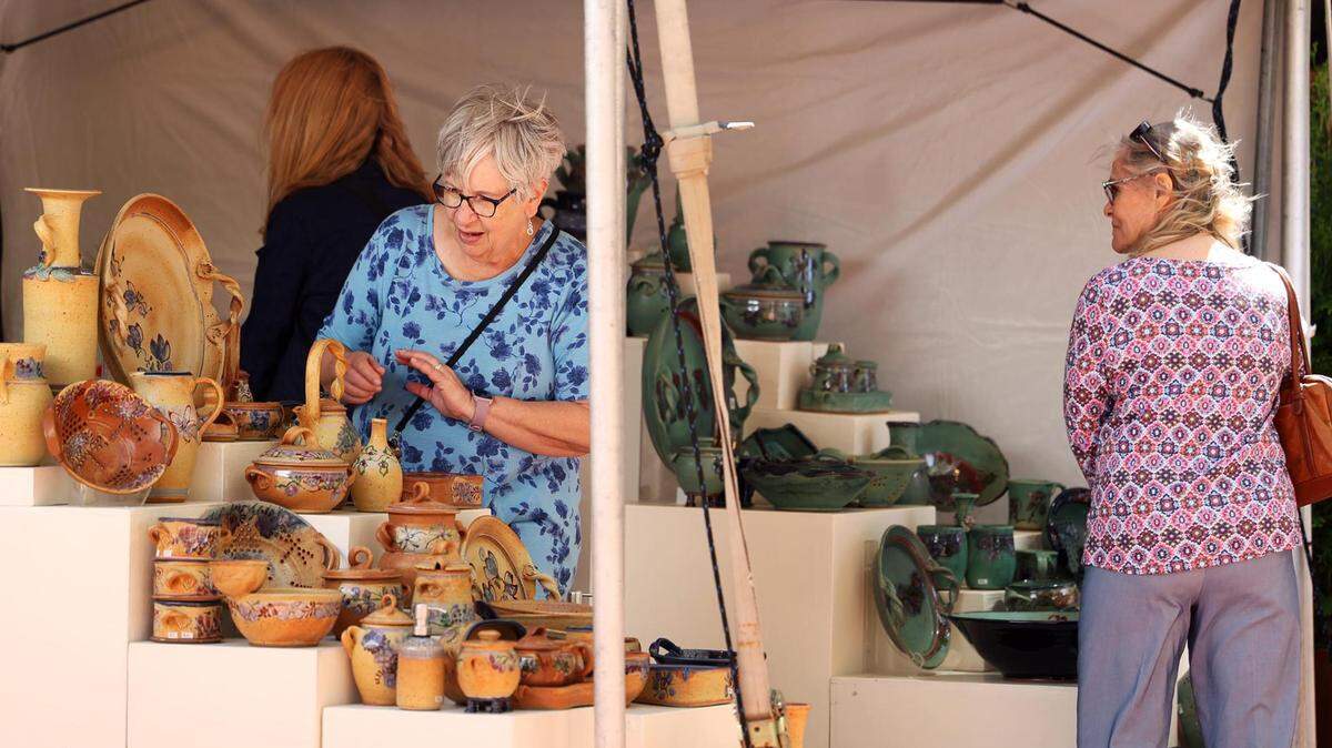 Visitors to the Main Street Arts Festival look at the pottery of one of the over 200 juried artists on Friday, April 21, 2023.