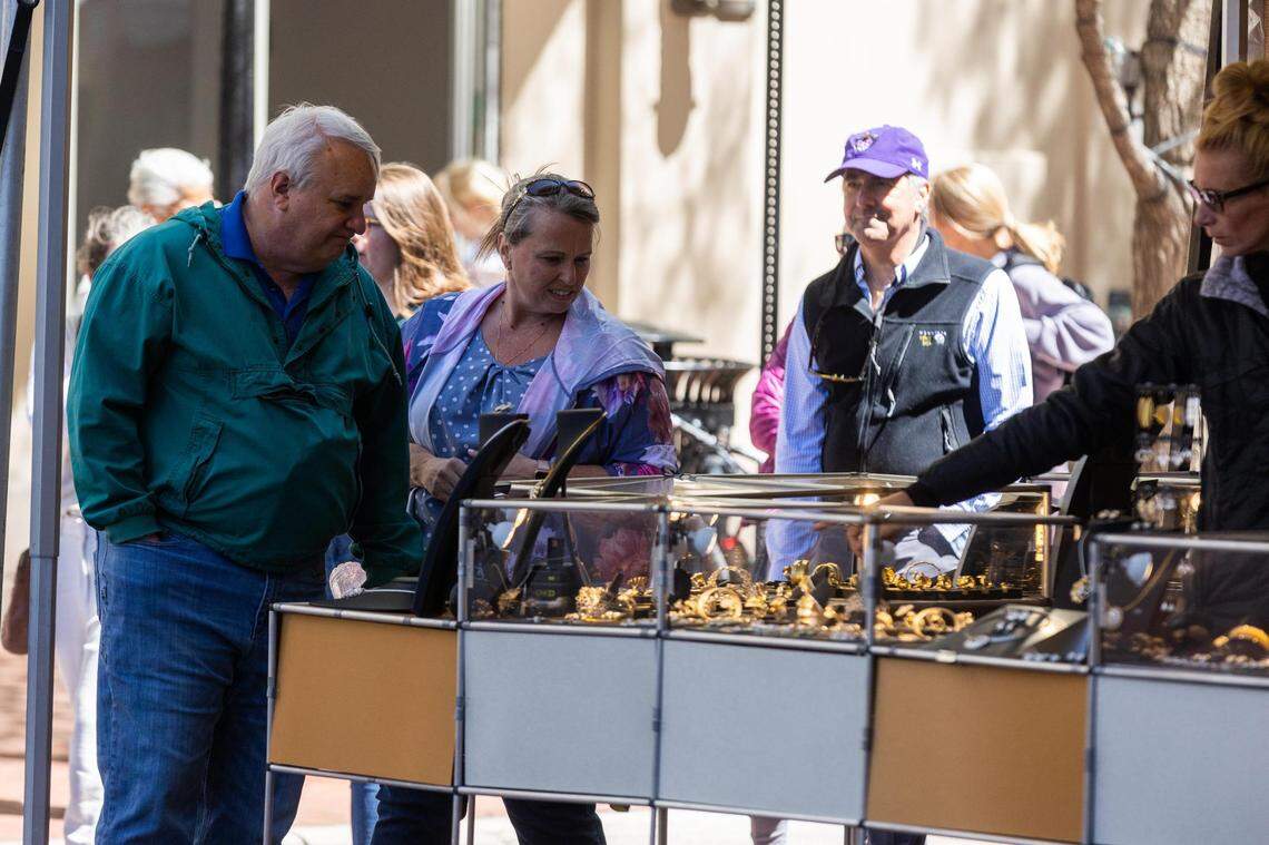 Festival goers check out art in booths during the Main Street Fort Worth Arts Festival Thursday, April 7, 2022, in downtown Fort Worth.