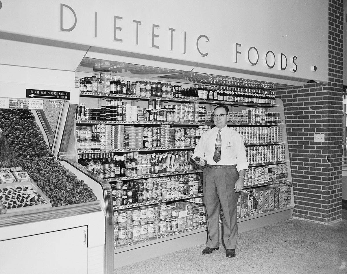 October 1953: Bill Gentry, assistant store manager at Wyatt Food Store No. 31 in Fair East Shopping Center, has dietetic foods ready for the formal opening on East Lancaster. Gentry is an experienced grocerman with many years experience with another Fort Worth food chain.