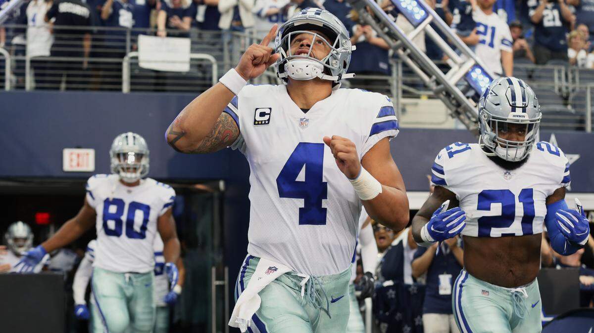Cowboys quarterback Dak Prescott, left, and runing back Ezekiel Elliott run onto the field to play the Detroit Lions on Sept. 30 at AT&T Stadium