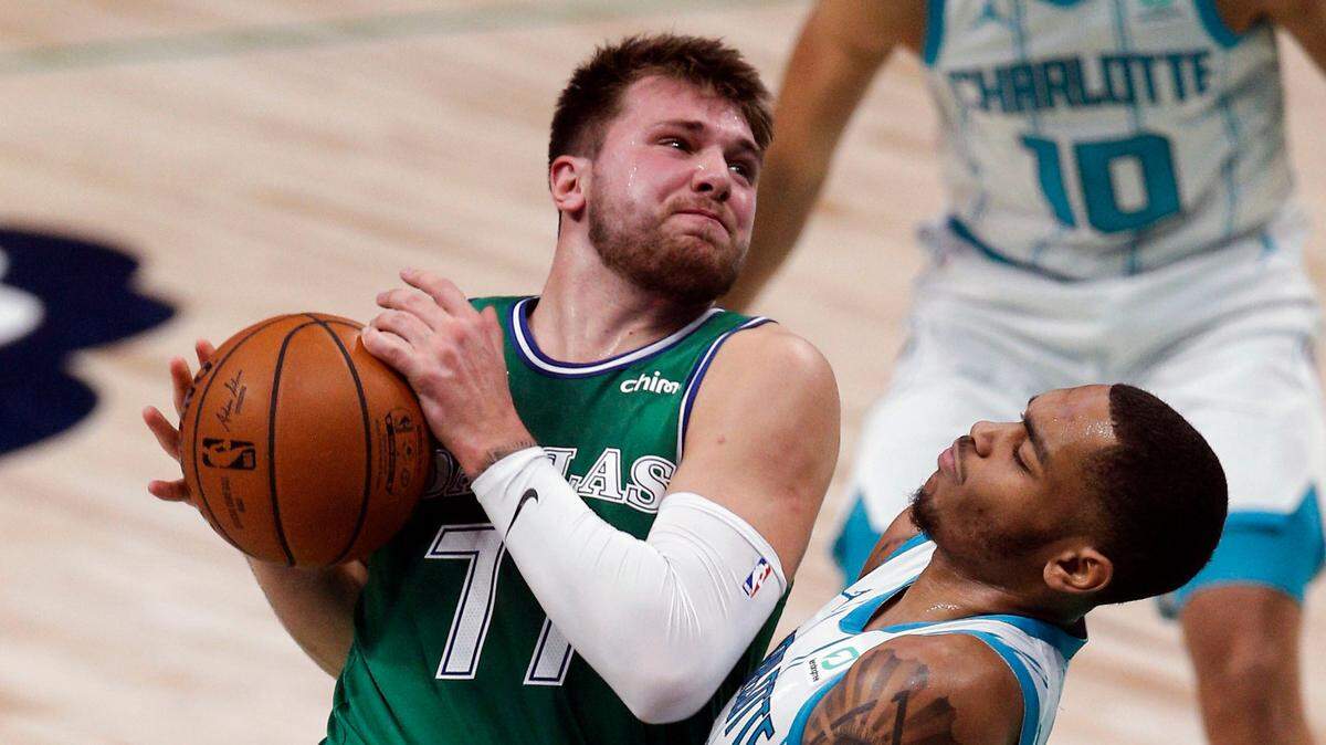 Dallas Mavericks guard Luka Doncic (77) battles Charlotte Hornets forward P.J. Washington (25) for space during the first half of an NBA basketball game, Wednesday, Dec. 30, 2020, in Dallas. (AP Photo/Brandon Wade)