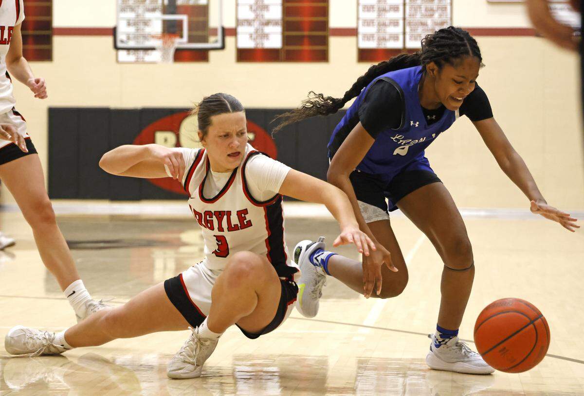 Argyle guard Addy Simms (3) and Mansfield Summit guard Aryn Williamson (2) go for a loose ball during the second half of a UIL Class 5A DII girls playoff basketball game at Saginaw High School in Saginaw, Texas, Thursday Feb. 19, 2026.