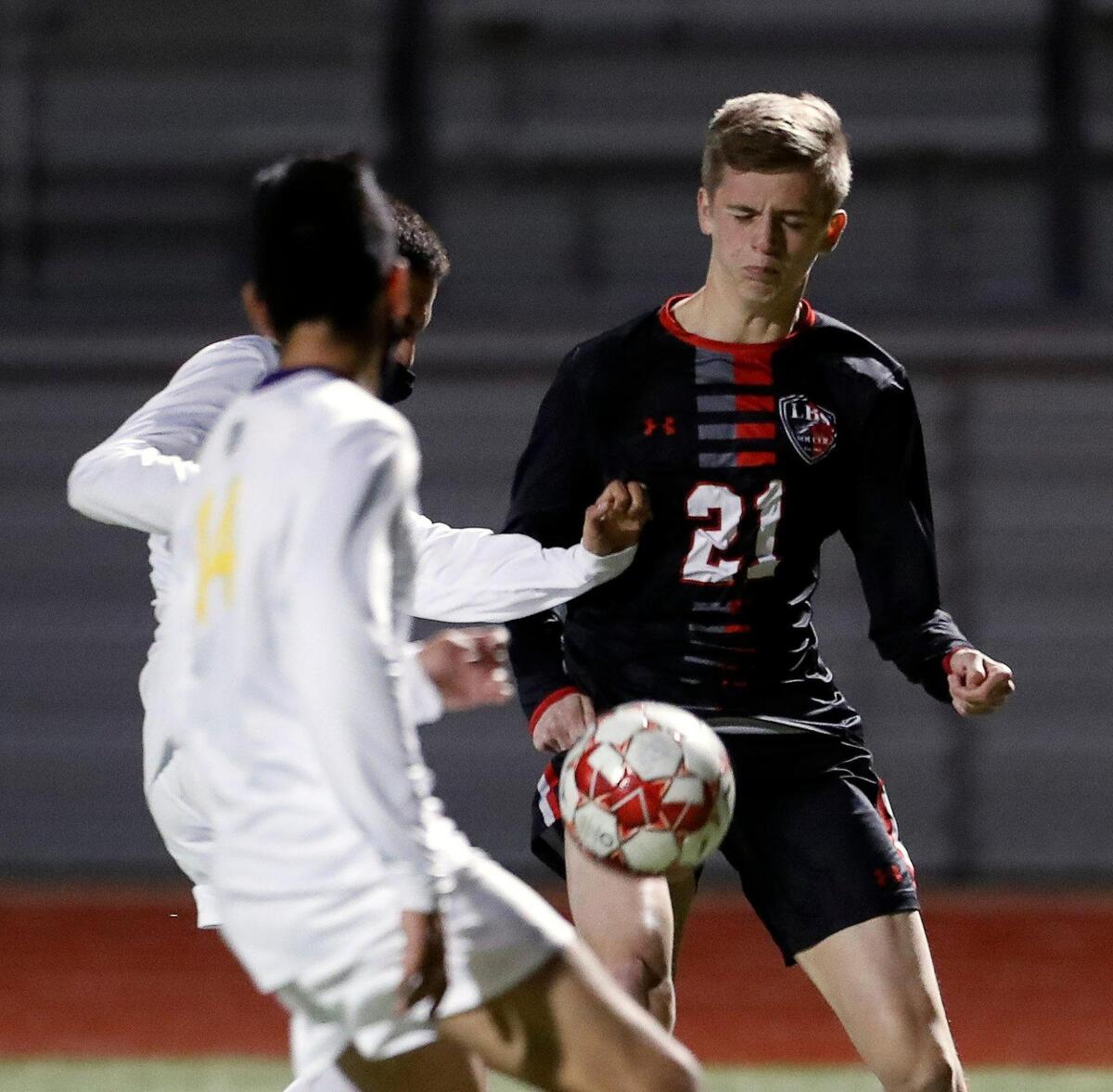 Legacy’s Zachary Planche (21) attempts to move the ball away from two Everman defenders during a district 8-5A high school soccer game at Mansfield Legacy High School in Mansfield, Texas, Wednesday, March 03, 2021. Legacy defeated Everman 5-1. (Special to the Star-Telegram Bob Booth)